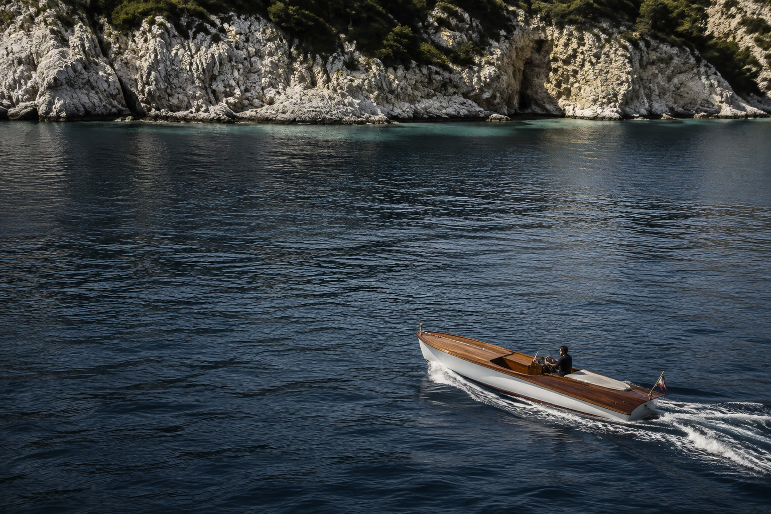 Small wooden tender crossing clear blue Aegean water